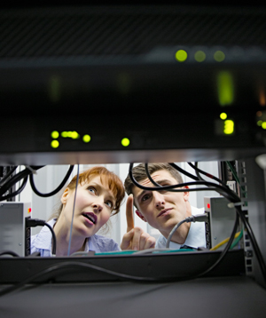Two technicians seen looking at an IT server.