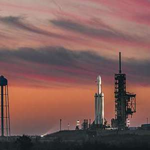 SpaceX launchpad against a red night sky.