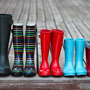 Front view of five pairs of colourful rain boots lined in a row.