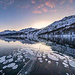 Frozen lake Sils with trapped ice bubbles and Piz Corvatsch in background, canton of Graubunden, Engadine, Switzerland