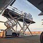 Preparation before flight. Loading of cargo containers to airplane at airport.