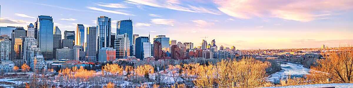 A colorful and cloudy morning sunrise sky over the downtown Calgary skyline in the winter.